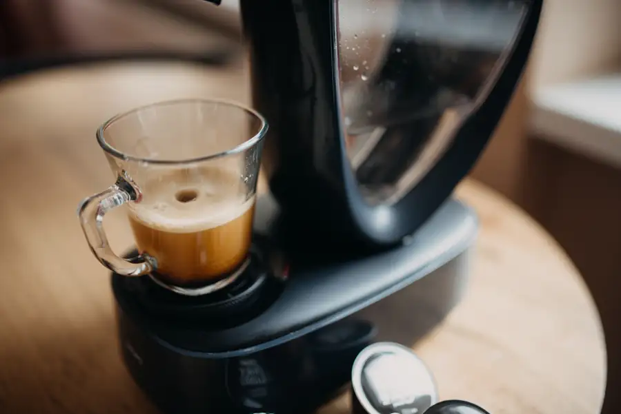 Espresso servido en una taza de cristal bajo la salida de una cafetera automática