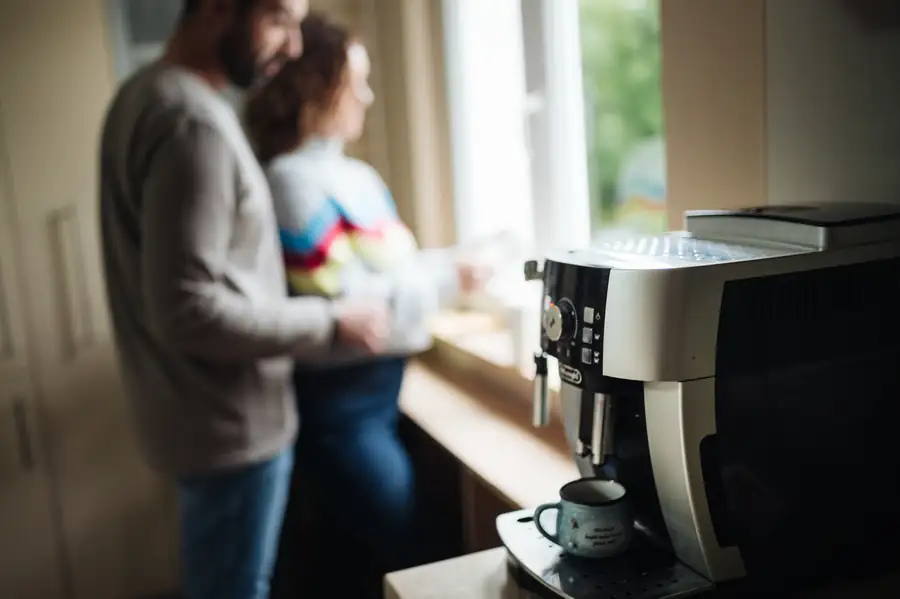 Cafetera superautomática en la cocina de una vivienda, con su panel de mandos y el tubo de vapor