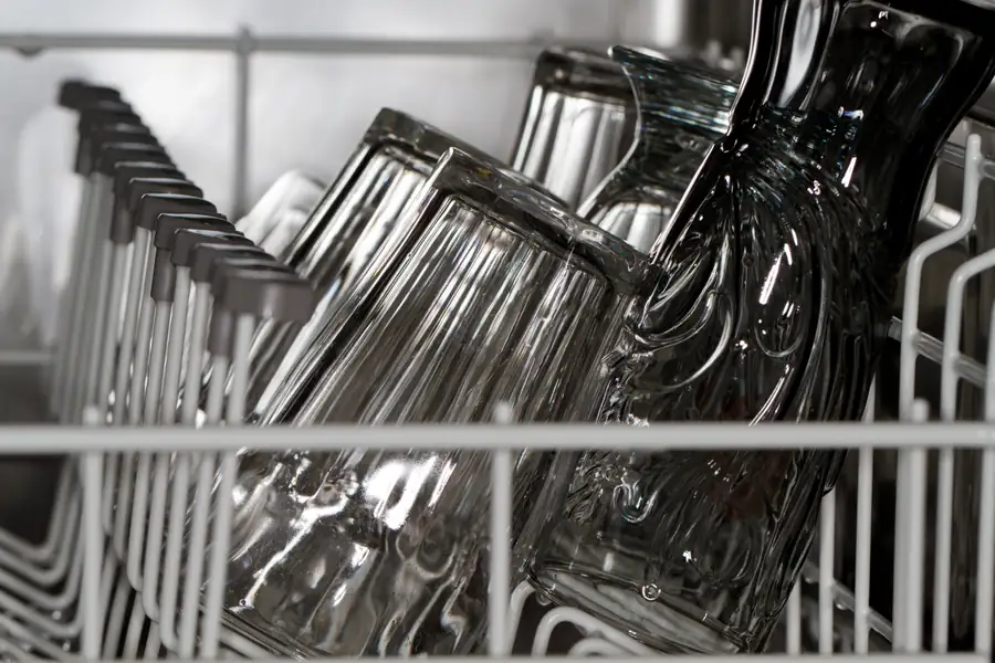 Vasos de cristal colocados boca abajo en la cesta de un lavavajillas